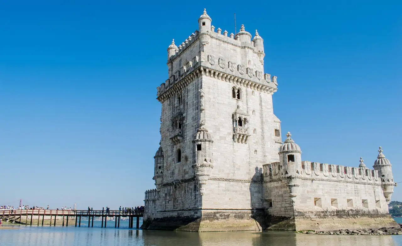 Belém Tower in Lisbon, white limestone against a clear blue sky beside the Tagus