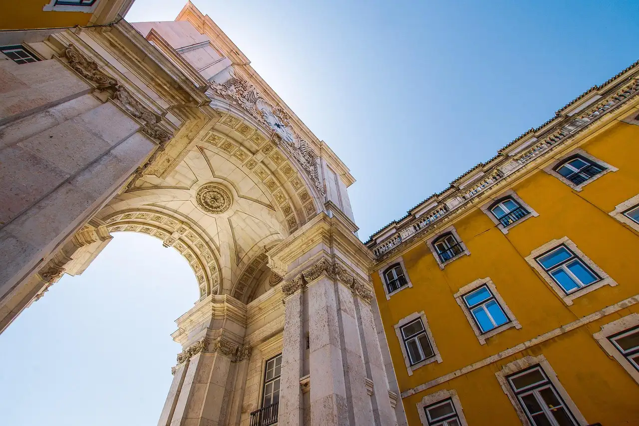 The Rua Augusta triumphal arch and a yellow facade seen from below