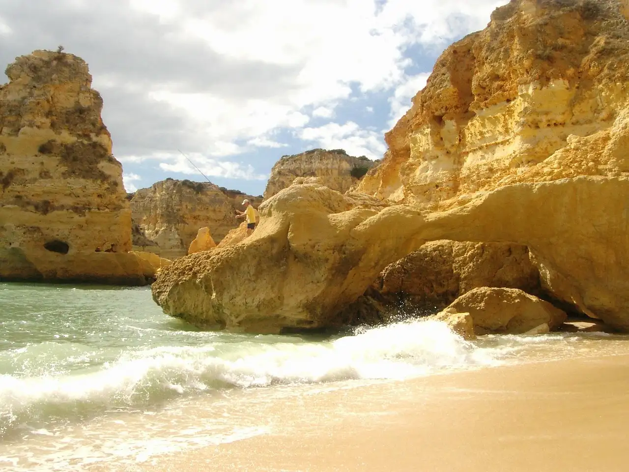 Golden sandstone cliffs and surf on an Algarve beach