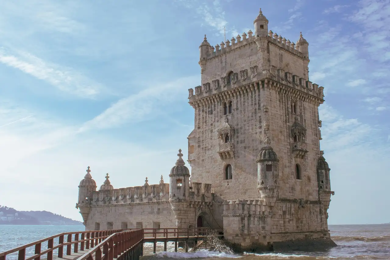 Close view of Belém Tower's battlements and turrets beside the Tagus with a wooden walkway