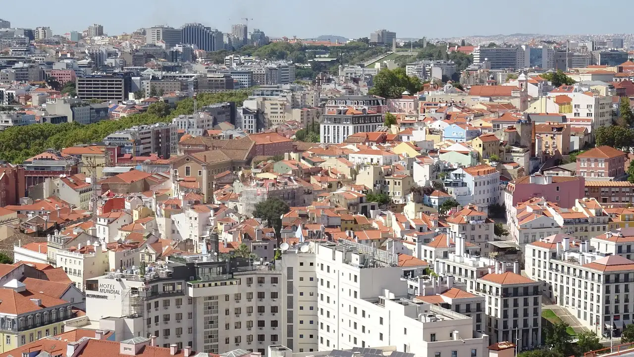 Panorama of Lisbon's old-town rooftops and hills seen from a high viewpoint