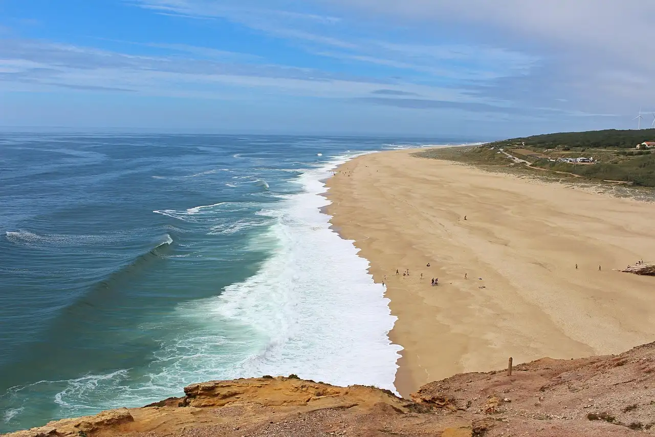 Nazaré's long sandy beach and breaking surf seen from the cliff top
