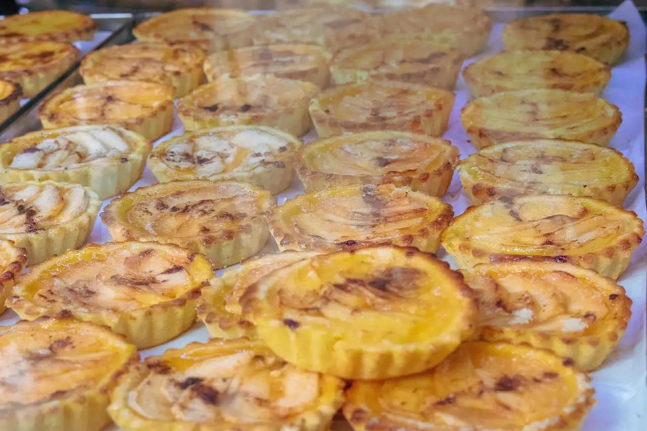 Rows of golden pastéis de nata custard tarts in a baking tray