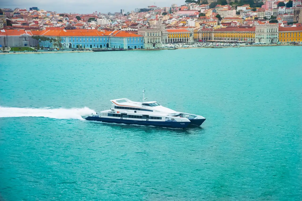 Tour boat speeding across the Tagus with Lisbon's colourful waterfront in the background