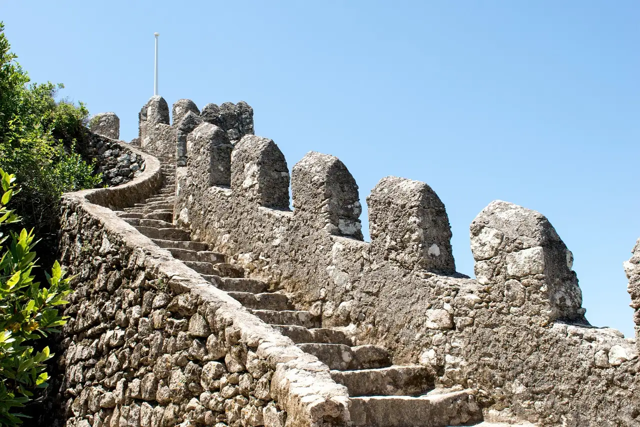 Crenellated walls and steps of the Castle of the Moors climbing the ridge above Sintra