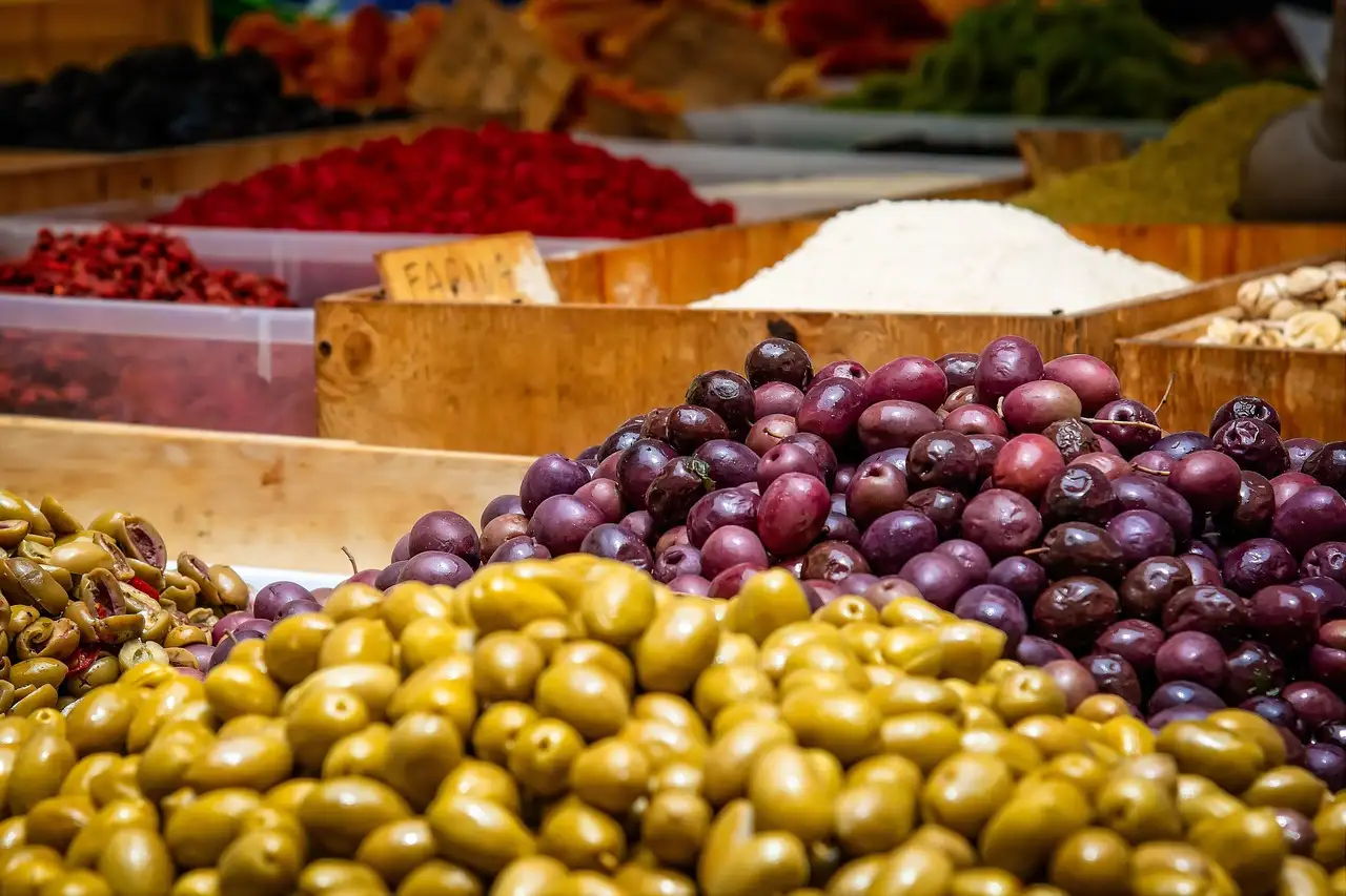 Trays of green and black olives at a market stall