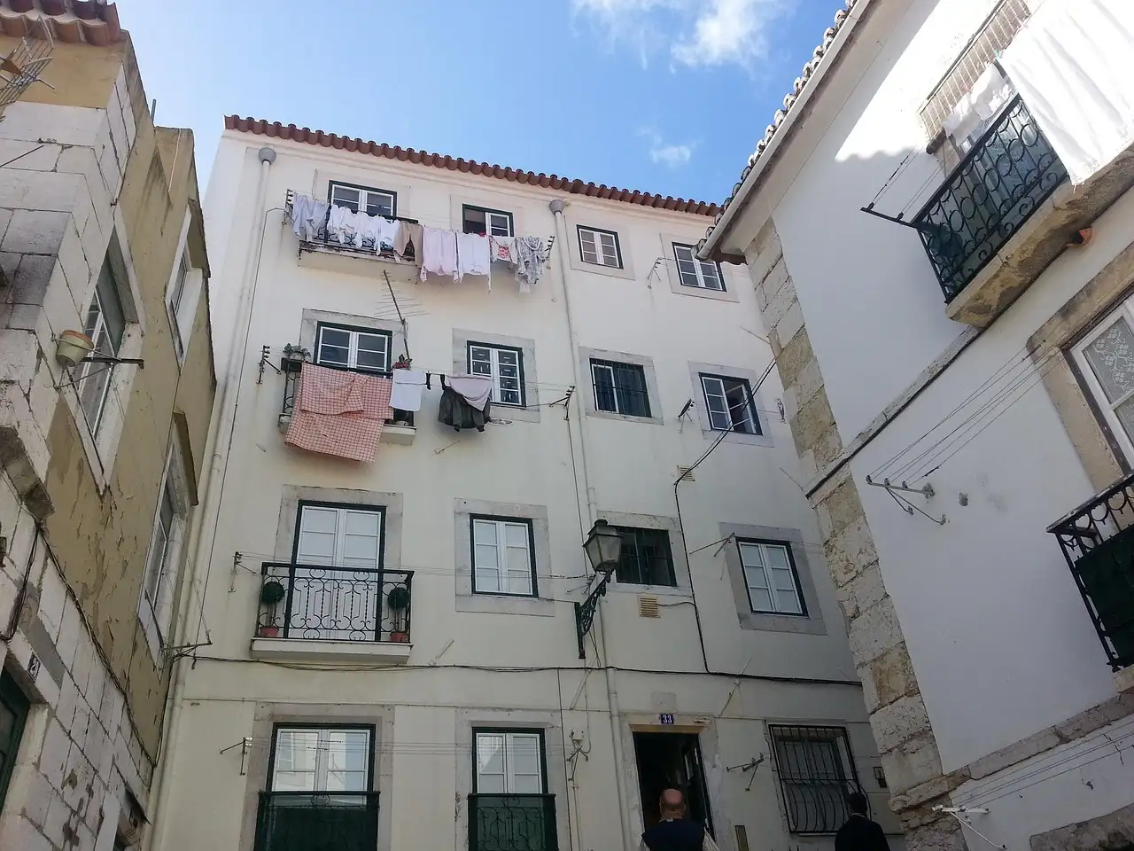 Whitewashed Lisbon apartment block with laundry drying on lines at the windows