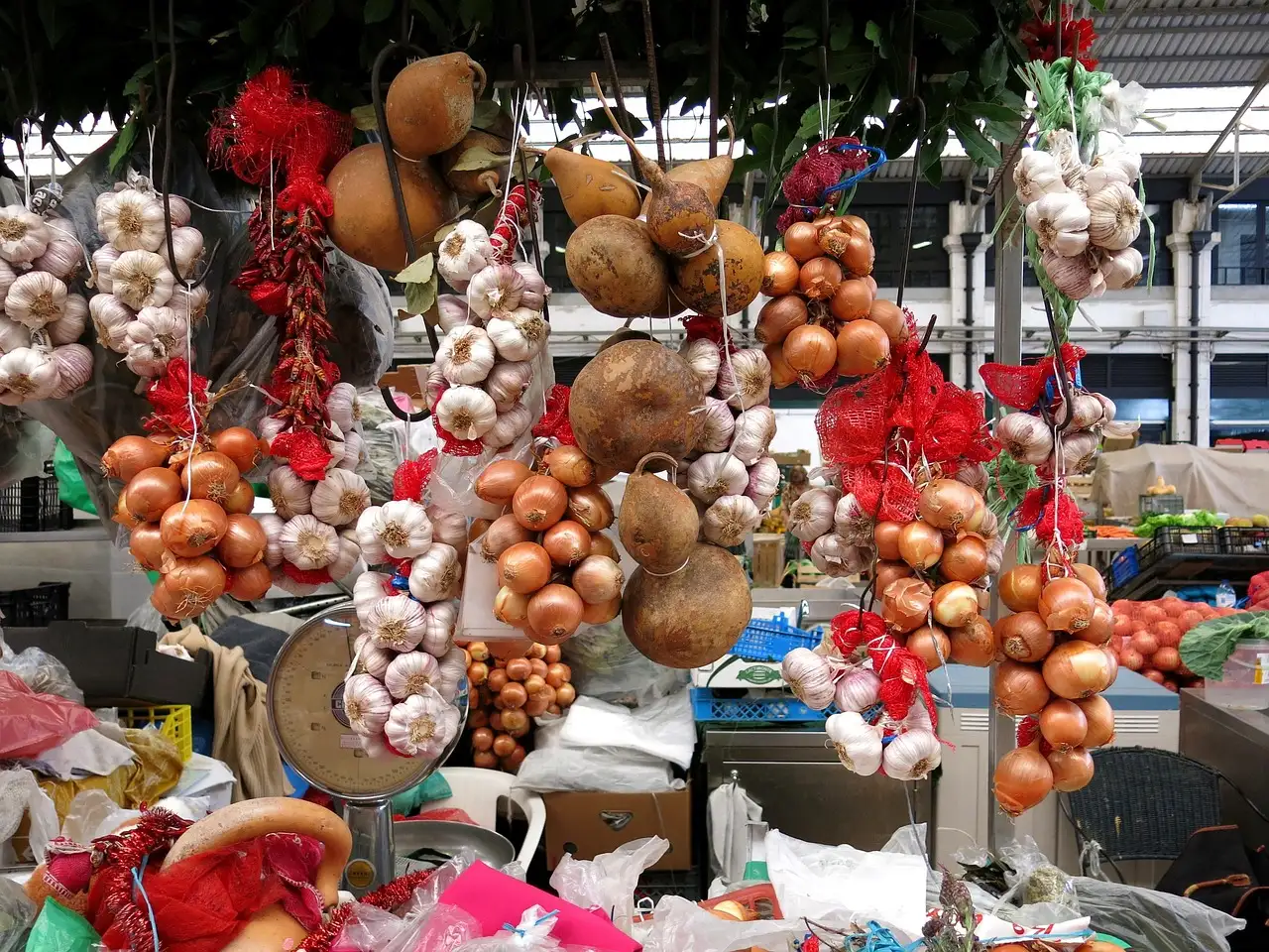 Market stall hung with strings of garlic, onions and dried red peppers