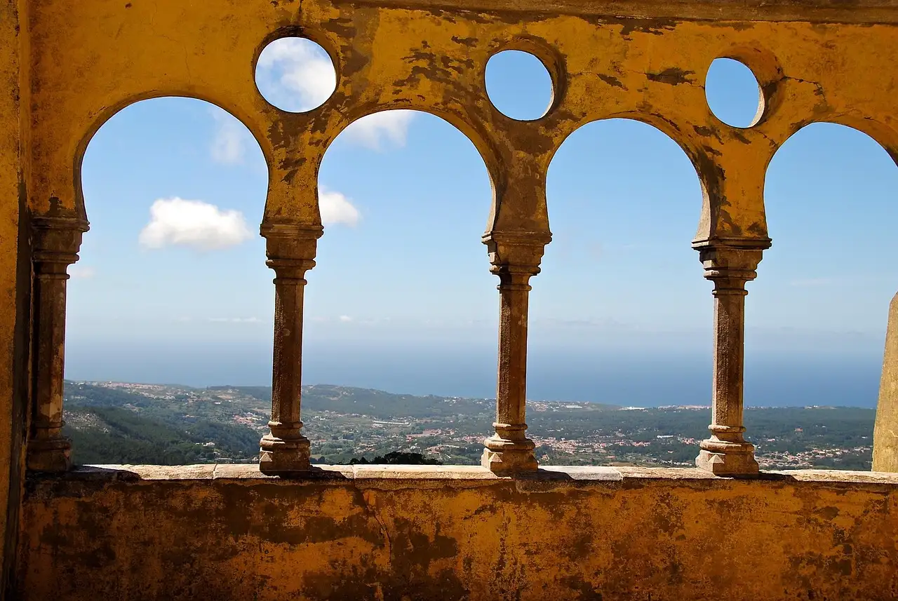 Moorish-style arches at Pena Palace framing a view over the Sintra hills