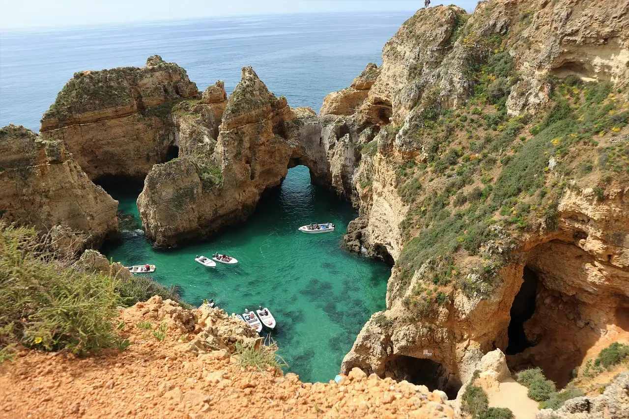 Golden cliffs, rock arches and turquoise water at Ponta da Piedade near Lagos, with small boats