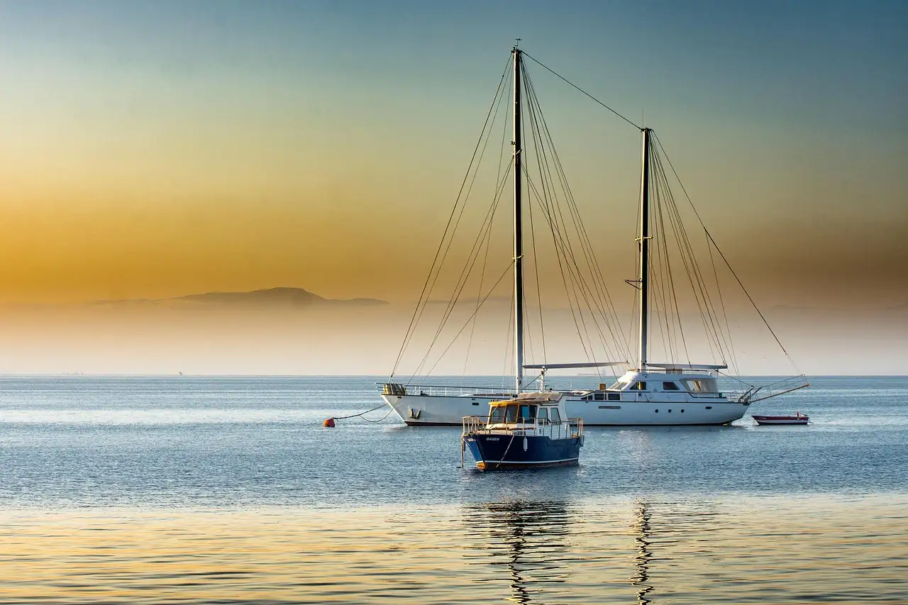 Sailing yachts at anchor on calm water in golden evening light