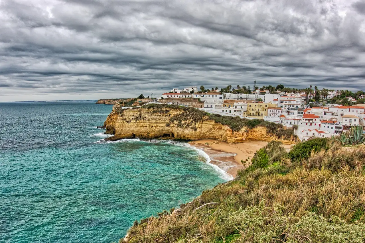Carvoeiro's white houses on golden cliffs above a turquoise sea