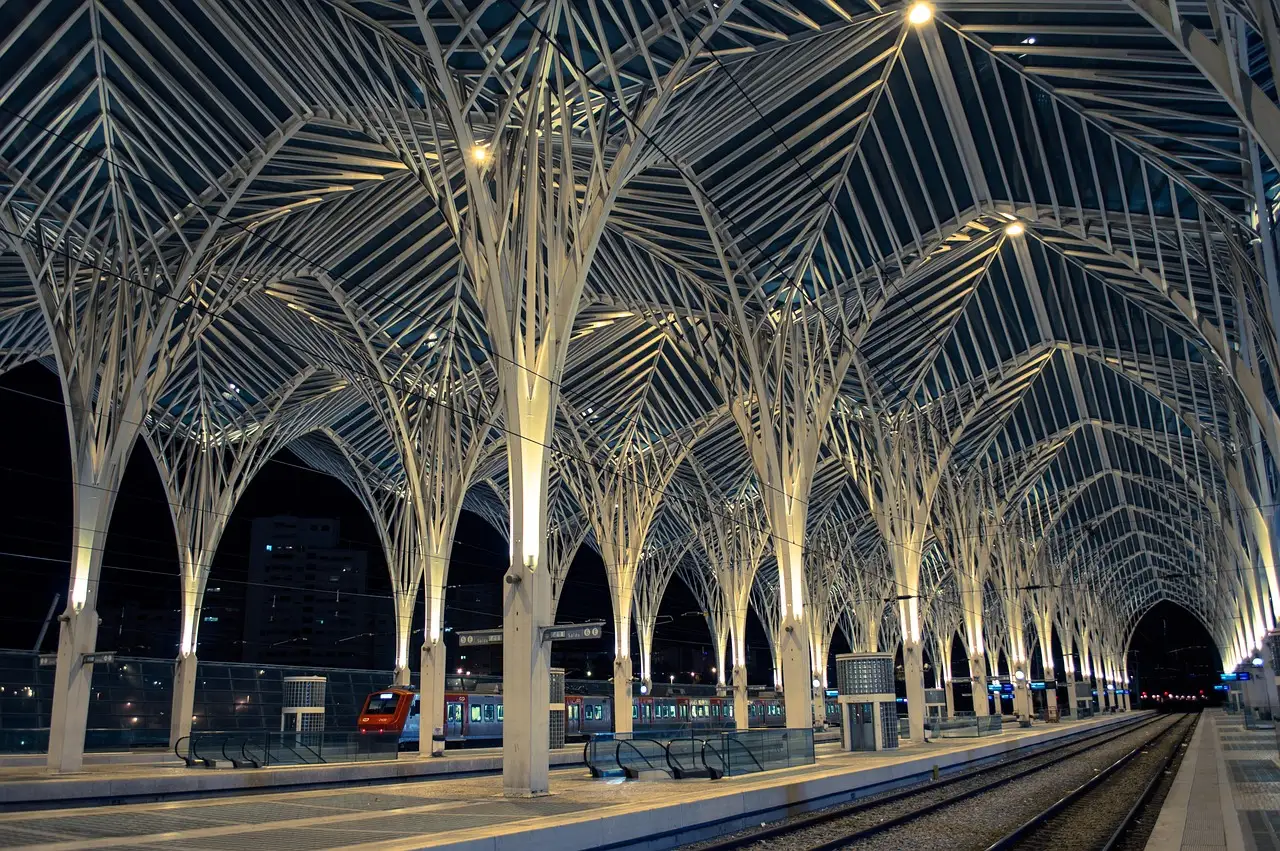 The white steel roof of Gare do Oriente, Lisbon's main long-distance railway station, lit at night above empty platforms and tracks